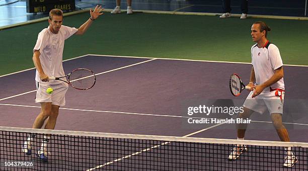 Kristof Vliegen of Belgium plays a backhand with team mate Xavier Malisse of Belgium looking on during their doubles match against Marcelo Melo and...