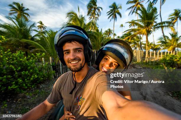 selfie of couple riding four-wheeler in taipu de fora beach, south bahia near barra grande, brazil - photo de film stock-fotos und bilder