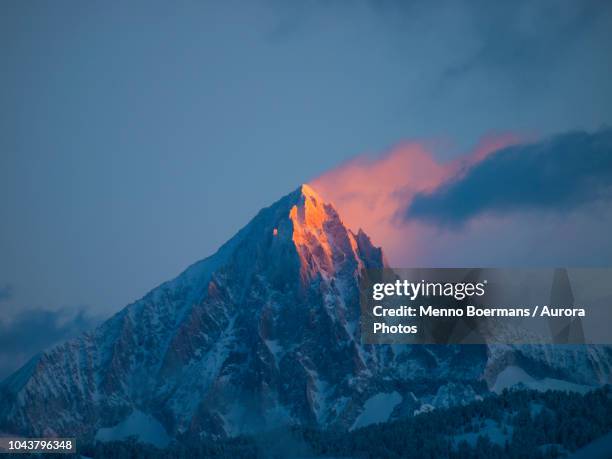 an early morning picture of the first sun rays setting the pyramid summit of the bietschhorn mountain on fire. - alpenglow - fotografias e filmes do acervo