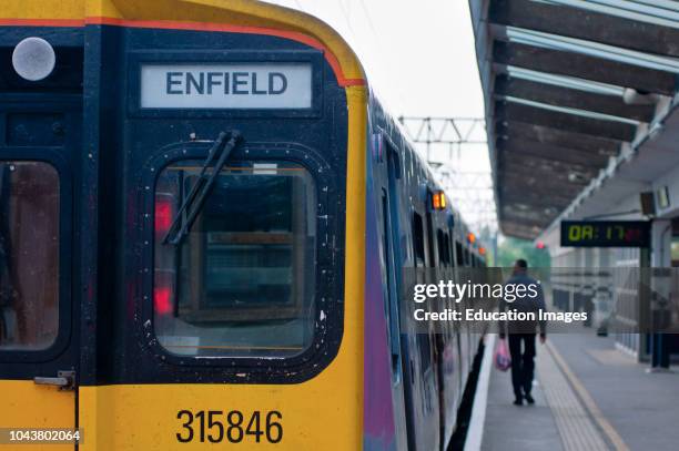 Suburban railway station and train, London, UK.