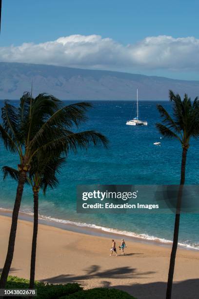 Maui, Hawaii Couple walking on the beach with the island of Lanai in the backgroundPhoto by: Education Images/Universal Images Group via Getty Images)