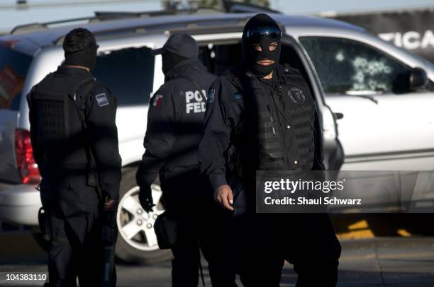 Federalis arrive at the Scene, where David Rodriguez Gardea and Antonio Bustillos Fierro were attacked and murdered by gunmen in three vehicles. The...