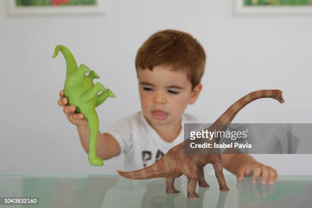 little boy playing with toy dinosaurs - dinosaur toy i - fotografias e filmes do acervo