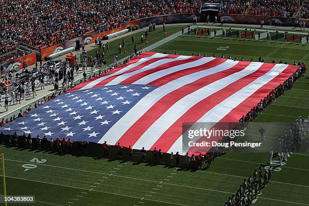 Giant American flag is heald above the field as the national anthem is observed as the Seattle Seahawks face the Denver Broncos at INVESCO Field at...