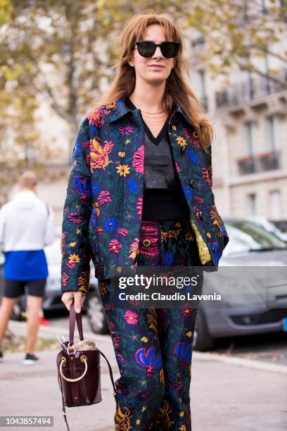Guest, wearing a blue printed suit, black top and burgundy bag, is seen before the Valentino show on September 30, 2018 in Paris, France.