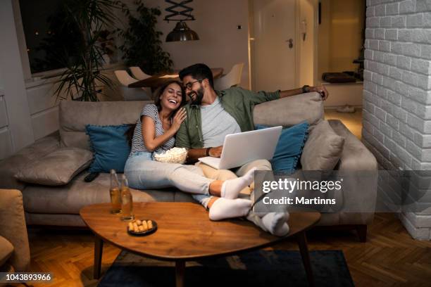 young couple watching a movie on a laptop. - young couple at movie together imagens e fotografias de stock