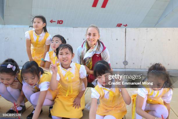 Aleksandra Krunic of Serbia poses for a picture with kids during the Little Painter event on day three of 2018 China Open at the China National...