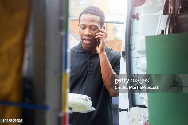 checking parts with client on the phone - plumber van stock pictures, royalty-free photos & images