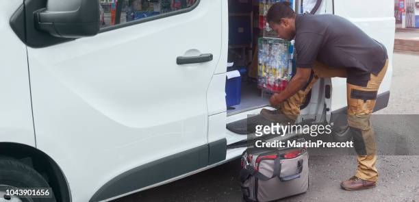 tradesman fastening shoe lace at his van - tradesman toolkit stock pictures, royalty-free photos & images