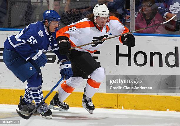 Korbinian Holzer of the Toronto Maple Leafs tries to hold up Scott Hartnell of the Philadelphia Flyers in a preseason game on September 23,2010 at...