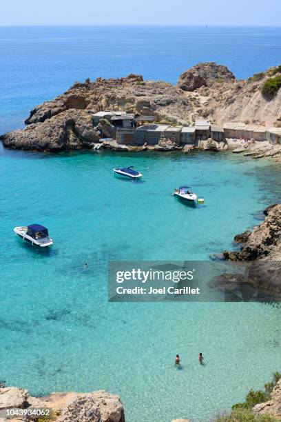 people and boats in the mediterranean sea at cala tarida, ibiza - ibiza strand stock pictures, royalty-free photos & images