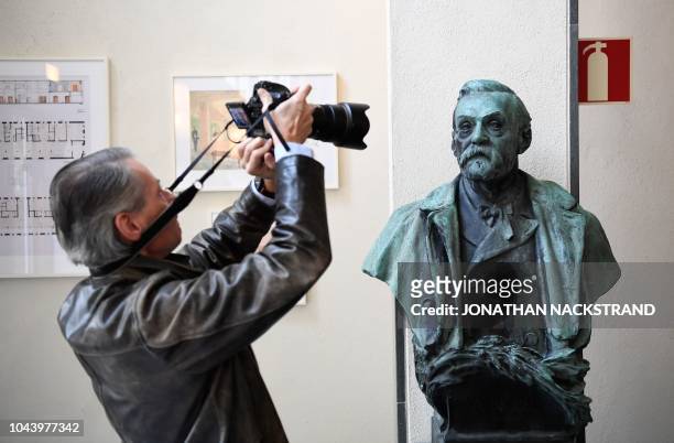 Man takes a picture of a statue of Swedish inventor and scholar Alfred Nobel prior to a press conference at the Karolinska Institute in Stockholm,...