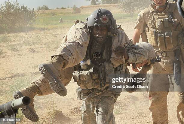 Army flight medic SGT Tyrone Jordan of Charlotte, NC attached to Dustoff Task Force Shadow of the 101st Combat Aviation Brigade carries Marine LCpl....