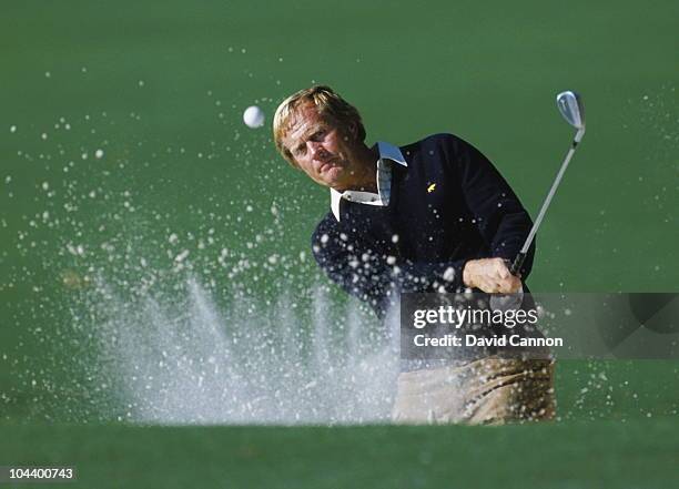 Jack Nicklaus of the USA keeps his eye on the ball as he hits out of the bunker with the sand creating a crown effect during the US Masters Golf...