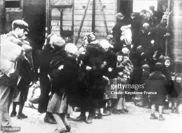 Women and young children getting out of a stock car at the arrival of the Auschwitz concentration camp.