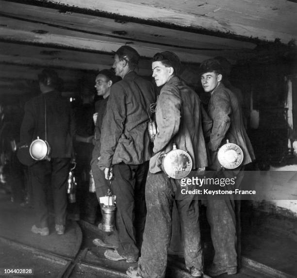 Britain. These miners are waiting in the gallery of a mine's well for the trucks charged with coal to go down from the surface where they are...