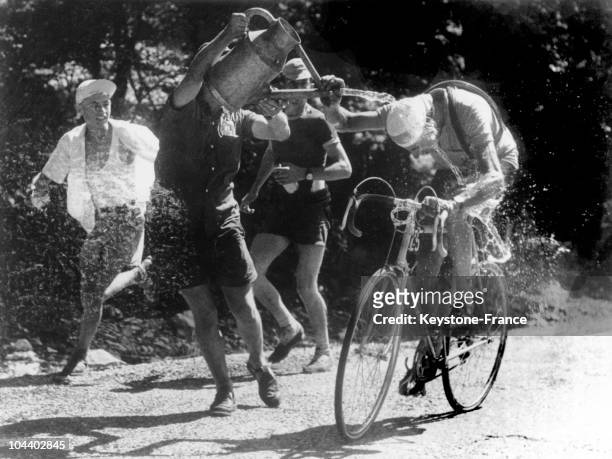 The Italian cyclist Fausto COPPI, leader of the 1952 Tour de France, being drenched with water by some of the spectators.