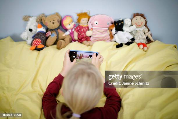 Girl is taking a picture of her puppets with a smartphone on August 14, 2018 in Berlin, Germany.