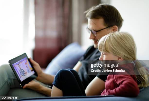 Father and a child are using a tablet together on August 14, 2018 in Berlin, Germany.