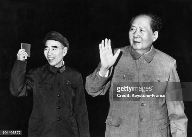 Vice president of the People's Republic of China holding the LITTLE RED BOOK and president MAO ZEDONG. They are greeting the crowd at an official...