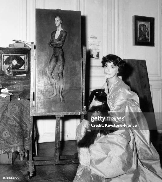 The Italian painter Leonor FINI and her Persian cat in front of the most beautiful paint of her exhibition at Drouant-David gallery in Paris. It is...