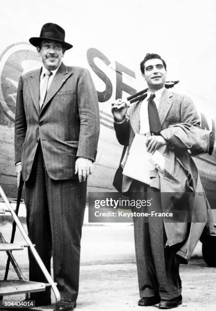 The American writer John STEINBECK and his friend Robert CAPA, the American photographer of Hungarian origin, posing before boarding a plane on July...