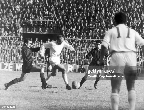 The Argentinan-Spanish soccer striker from the Real Madrid Alfredo DI STEFANO dribbled round two Milanese players. From the back : the Spanish left...