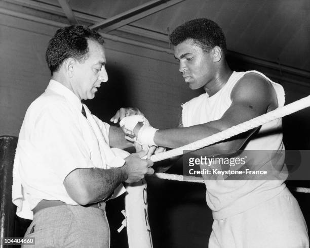 The American boxer Muhammad ALI having his hand banded by his trainer Angelo DUNDEE, in White City. The heavyweight champion was training in Army...