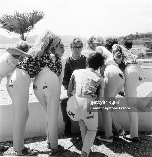 During Cannes film festival, the British actor Michael CAINE promoted his film ALFIE, in which he starred, by surrounding himself with young women...