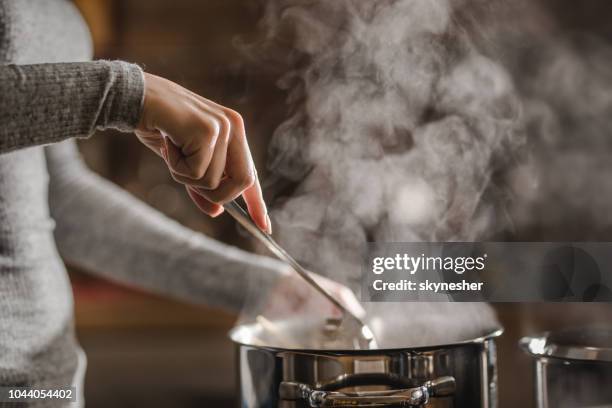 nicht erkennbare frau mittagessen in der küche und rühren suppe machen. - pfanne stock-fotos und bilder