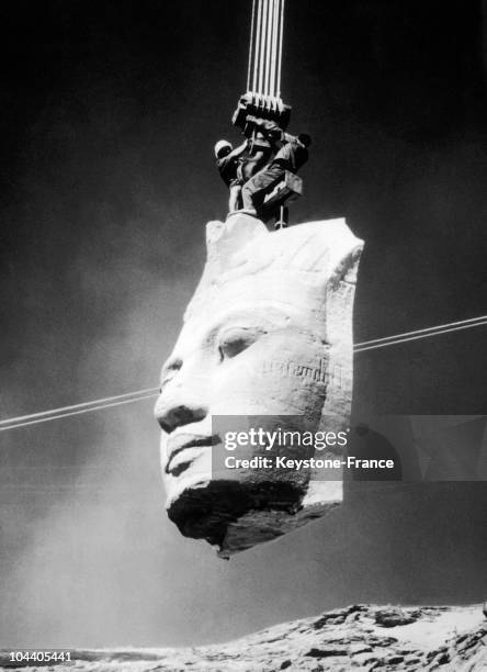 One of the heads of the Pharaoh RAMSES II which was on the facade of the great temple of Abu Simbel in Nubia, Egypt, being carried by cranes to the...