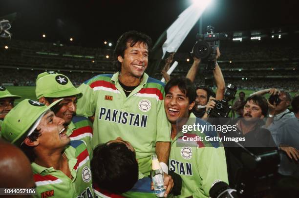 Pakistan captain Imran Khan celebrates with team mates as photographer David Munden looks on after the 1992 Cricket World Cup Final victory against...