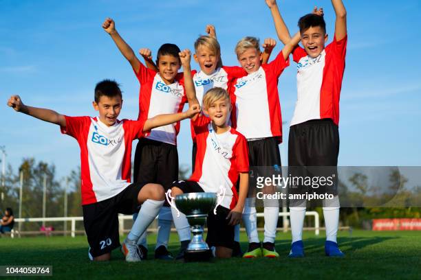 team foto erfolgreich junior soccer team 10 jahre alten jungen feiert ersten platz - 10 11 years boy stock-fotos und bilder