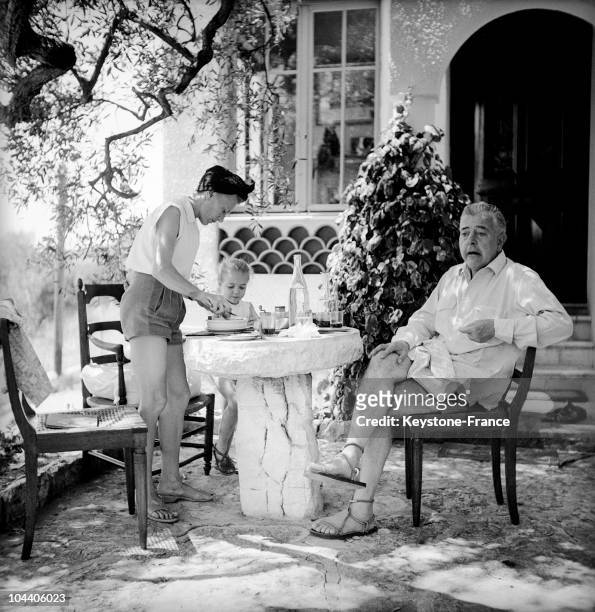 The French poet Jacques PREVERT relaxing while on vacation in St Paul de Vence in the summer of 1951, pictured on the terrace at his villa with his...
