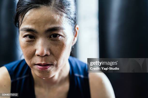 mature femme adulte, entraînement au gymnase de boxe - gants de sport photos et images de collection