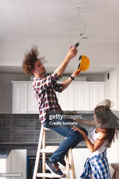 man changing light bulb in new home - electrical failure stock pictures, royalty-free photos & images