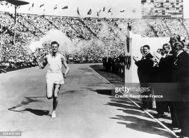 Opening ceremony of the Summer Olympics at Wembley Stadium . The last torch bearer, John MARK, running in front of the VIP stand to the applause of...