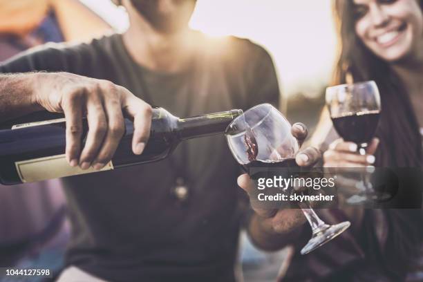 close up of pouring red wine into a glass outdoors. - pouring stock pictures, royalty-free photos & images