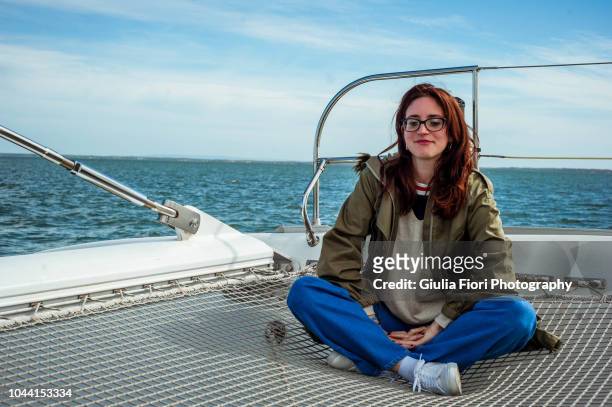 young woman sitting on the deck of a boat - parka stock pictures, royalty-free photos & images