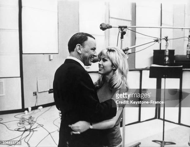 The American singer Franck SINATRA and his daughter Nancy SINATRA taking a break during the recording session of a duet in a Hollywood studio, around...
