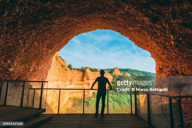 tourist admiring the view from a lookout of a cave in las medulas, spain. - provincia de león fotografías e imágenes de stock