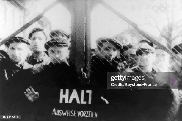 Between January 26 and 27 some survivors dispersed behind the gates of the camp at AUSCHWITZ, are watching the arrival of Soviet troops, who have...