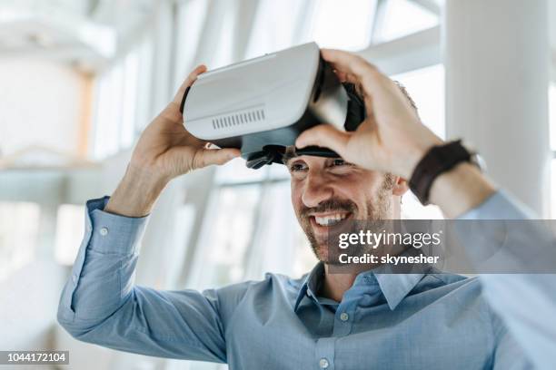 happy entrepreneur having fun while using virtual reality simulator. - virtual reality gaming stock pictures, royalty-free photos & images