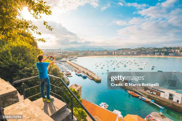 tourist photographing la concha bay and san sebastian, spain - spanish basque country 個照片及圖片檔