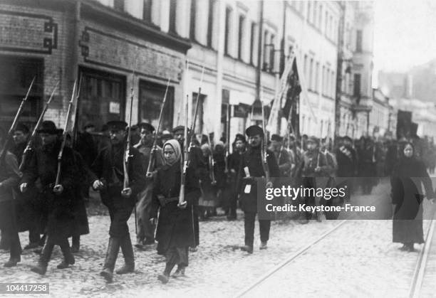 Workers and soldiers who fled the front, along with women, parading in arms in the streets of Petrograd after the first Russian Revolution of...
