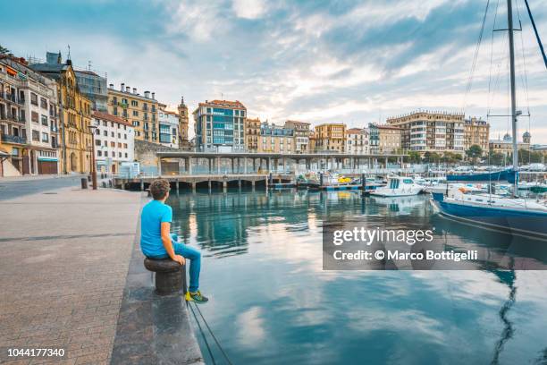 tourist admiring the view of the old town in san sebastian - san sebastian photos et images de collection