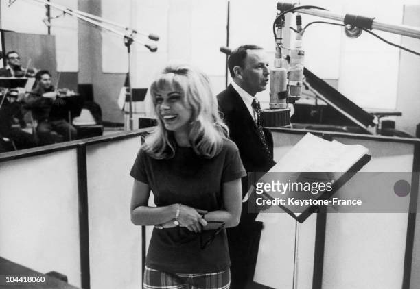 The American singer Franck SINATRA and his daughter Nancy SINATRA taking a break during the recording session of a duet in a Hollywood studio, around...