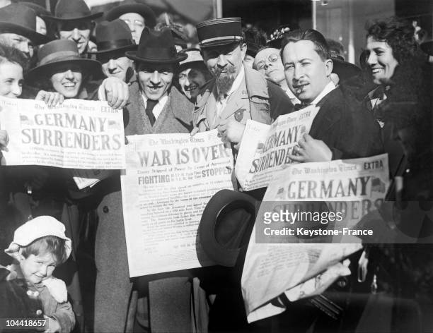 Jubilant crowd holding copies of the Washington Times newspaper after the signing of the Armistice ending World War I, USA, 11th November 1918. The...
