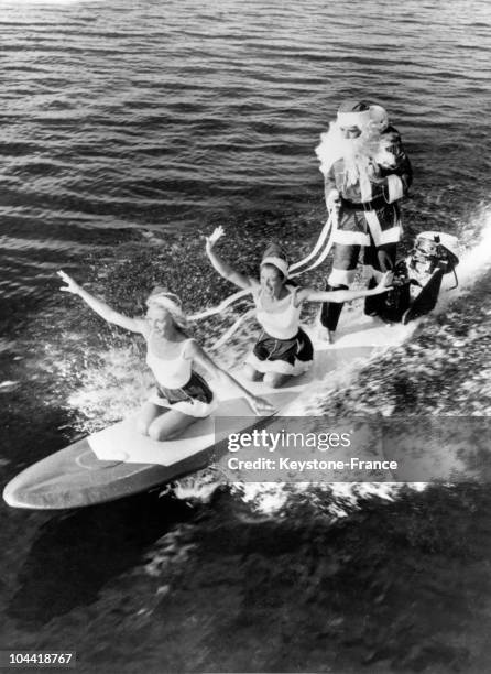 Surfer Santa Claus, Arriving On A Motorized Surfboard With Two Mrs. Claus, In Cypress Gardens, Florida, In The 1970'S.
