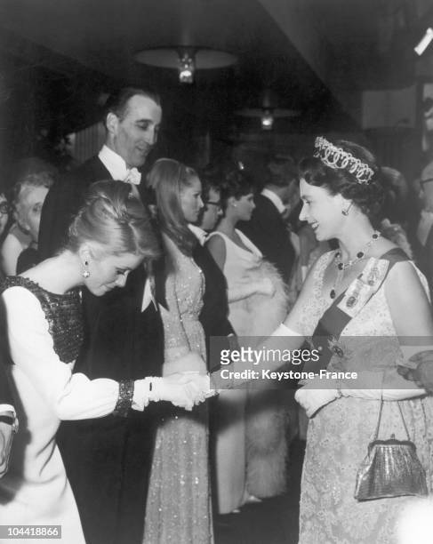 On March 15 The French Actress Catherine Deneuve Salutes Queen Elizabeth Ii Of England, Beside Christopher Lee, Woody Allen And Ursula Andress During...